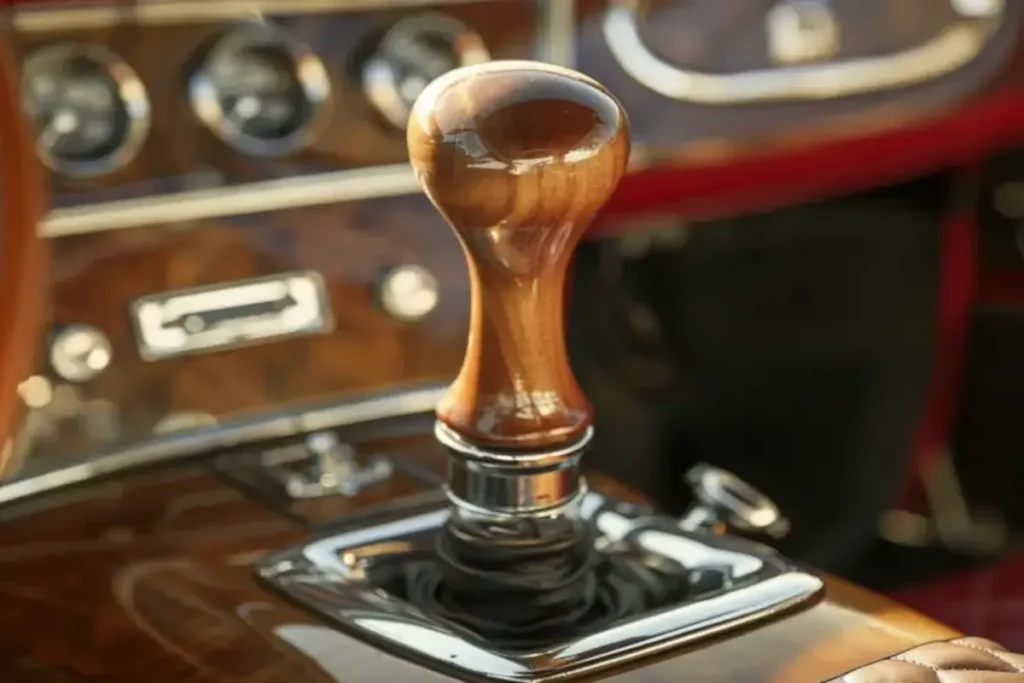 A vintage car's stick shift with a wooden handle and chrome accents, surrounded by aged leather upholstery and classic dials, captured in warm golden-hour sunlight. The image symbolizes downshifting as a mindful practice in both driving and life, reflecting balance, intentionality, and timeless wisdom.